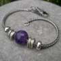 single amethyst bead and silver beads on a bracelet