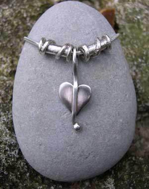 small silver heart pendant with twist beads on a snake chain